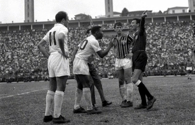Pelé discute com o árbitro, enquanto Bellini observa